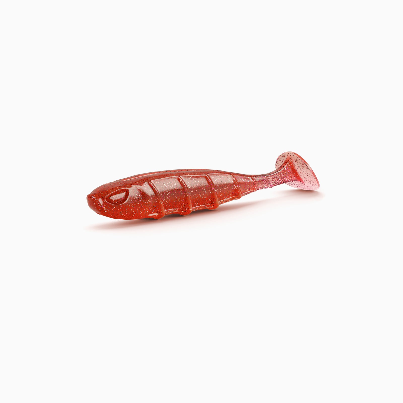 Das Bild zeigt einen Paddle-Tail-Gummiköder mit realistischem Augen-Design, typischer Rippenstruktur und schlankem Körper. Der Körper ist im auffälligen rot gehalten, helle und dunkele Partikeln bilden einen Kontrast.