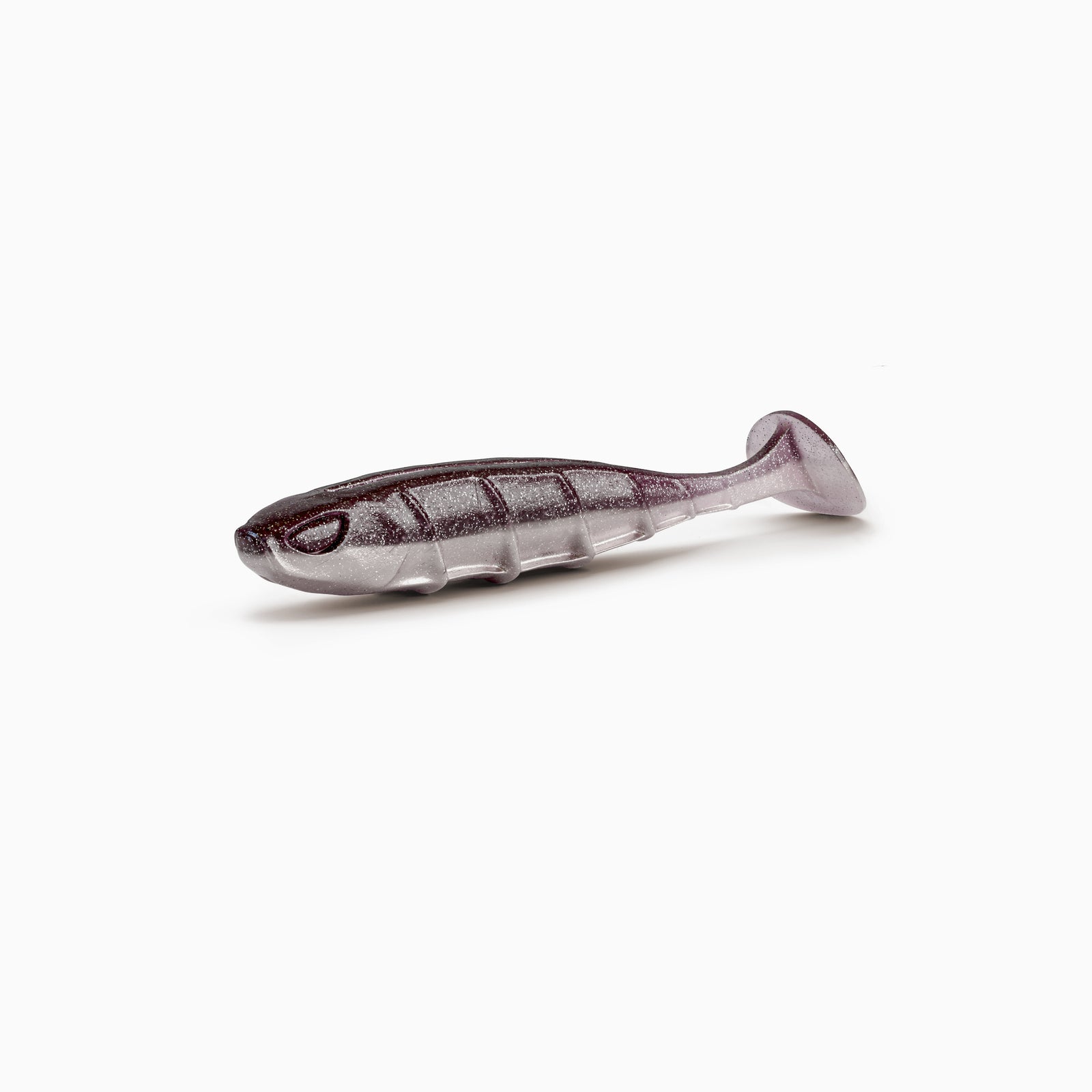 Das Bild zeigt einen Paddle-Tail-Gummiköder mit realistischem Augen-Design, typischer Rippenstruktur und schlankem Körper. Der Körper ist in gedecktem braun-grau gehalten, während der Bauch einen hellgrauen Kontrast mit silbernen Partikeln bildet.