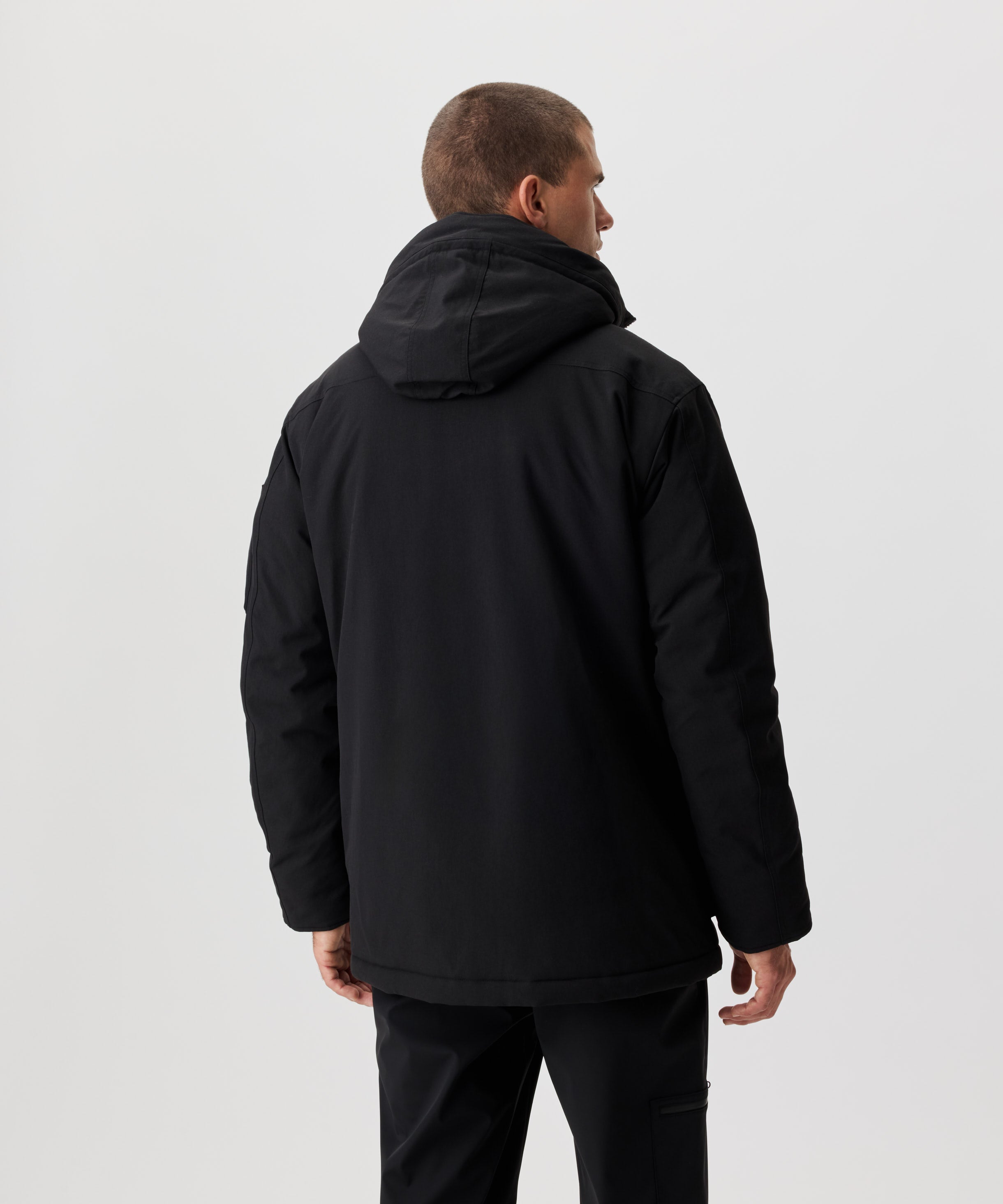 Rüclansicht Mann im schwarzen Winter-Parka.