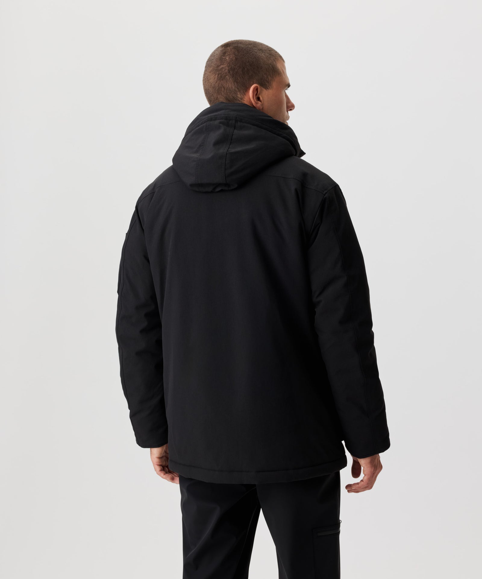 Rüclansicht Mann im schwarzen Winter-Parka.