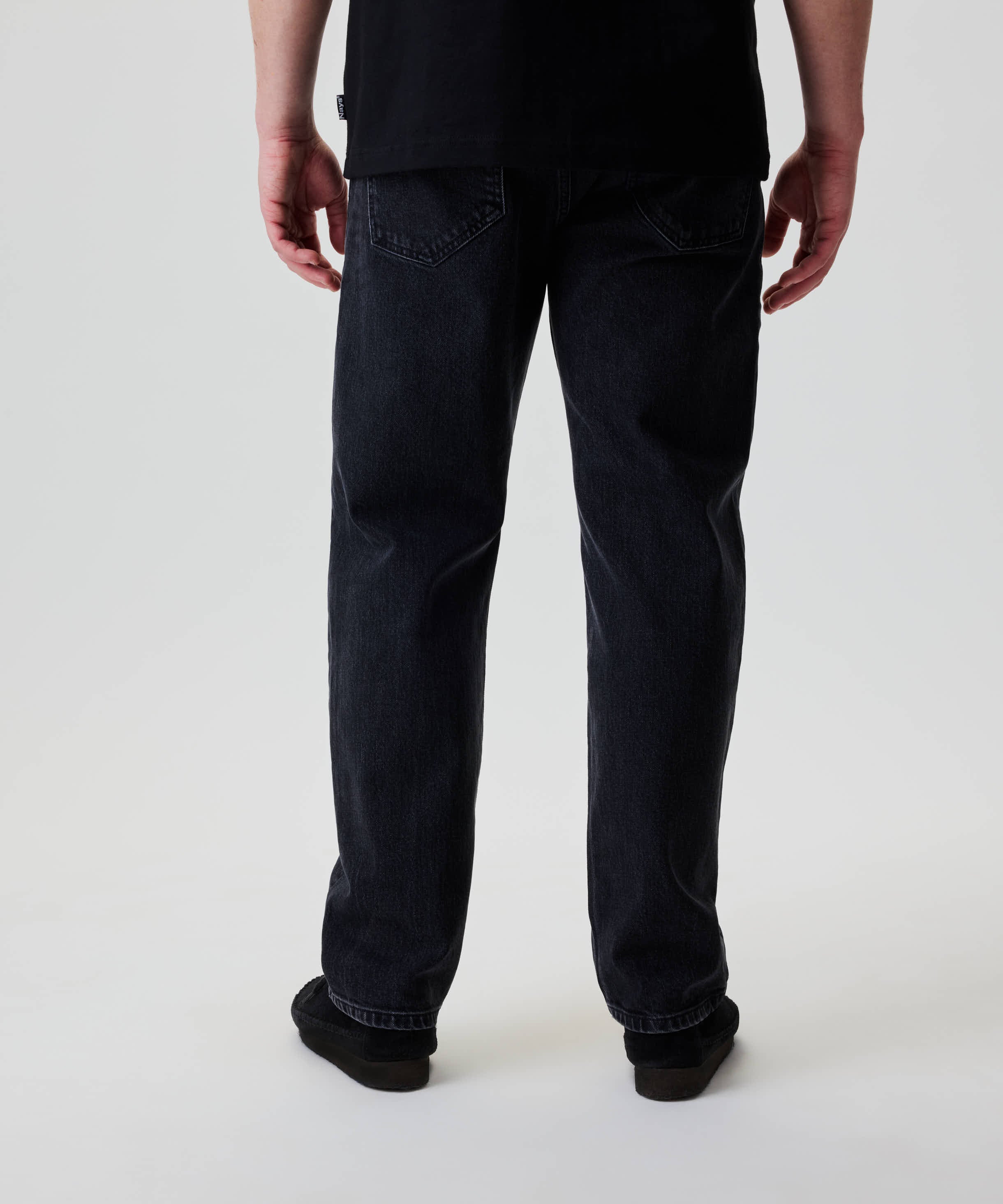 Rückansicht einer Person in Nays Regular Fit Jeans mit klassischem 5-Pocket-Design und geradem Schnitt, getragen mit dunklen Schuhen.