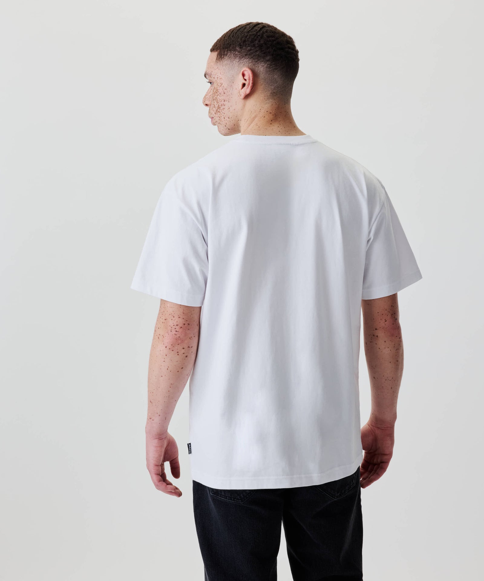 Rückansicht einer Person im Nays Loose Fit Chest Print Tee mit kurzem Haar, zeigt den lässigen, oversized Stil des T-Shirts.